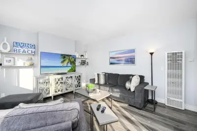 a living room with a couch and a tv at 1 Bedroom Apartment in the back of our Oceanfront Home in Newport Beach