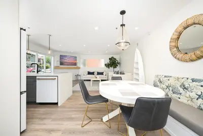 a kitchen and living room with a white table and chairs at Perfect Renovated and Modern Duplex on Balboa Island in Newport Beach