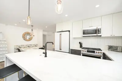 a kitchen with white cabinets and a white counter top at Perfect Renovated and Modern Duplex on Balboa Island in Newport Beach