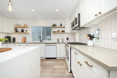 a white kitchen with white cabinets and white appliances at Perfect Renovated and Modern Duplex on Balboa Island in Newport Beach