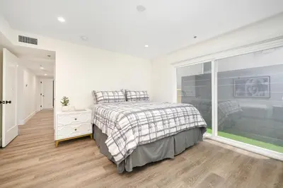 a white bedroom with a bed and a large window at 3 Bedroom Renovated Condo on Balboa Island in Newport Beach