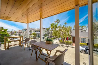 a patio with a table and chairs and a view of a street at 4 bedroom Renovated Home on Balboa Island in Newport Beach