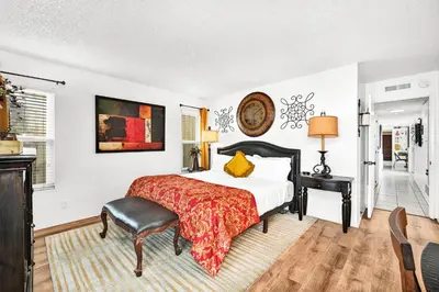 a bedroom with a bed and a table and a chair at Spanish Castle By The Sea in Newport Beach in Newport Beach