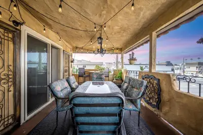 a table and chairs on a balcony with a view at Spanish Castle By The Sea in Newport Beach in Newport Beach
