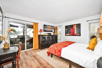 a bedroom with a bed and a desk and a window at Spanish Castle By The Sea in Newport Beach in Newport Beach