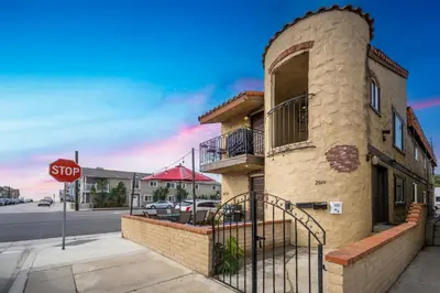 a building on the corner of a street with a stop sign at Charming 1-Bedroom Home on 29th Street in Newport Beach