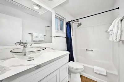 a white bathroom with a sink and a toilet at Charming 1-Bedroom Home on 29th Street in Newport Beach