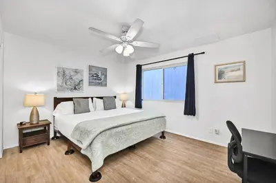 a bedroom with a bed and a ceiling fan at Spanish Castle in Newport Steps to the Sand and Grocery Store in Newport Beach