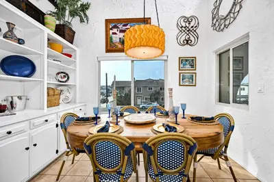 a dining room with a wooden table and chairs at Spanish Castle in Newport Steps to the Sand and Grocery Store in Newport Beach