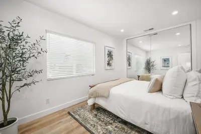 a white bedroom with a bed and a window at Remodeled - Modern - 2 Bedroom - Walk to the Beach in Newport Beach