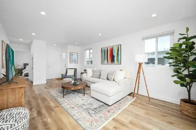 a living room with a white couch and a table at Remodeled - Modern - 2 Bedroom - Walk to the Beach in Newport Beach