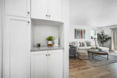 a living room with white cabinets and a couch at Remodeled - Modern - 2 Bedroom - Walk to the Beach in Newport Beach