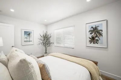 a white bedroom with a bed and a window at Remodeled - Modern - 2 Bedroom - Walk to the Beach in Newport Beach