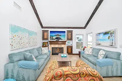a living room with blue couches and a fireplace at 3 Bedroom Luxury Home Steps to Balboa Fun Zone in Newport Beach
