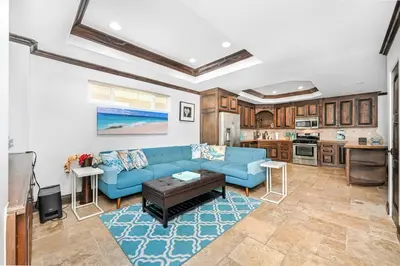 a living room with a blue couch and a kitchen at 3 Bedroom Luxury Home Steps to Balboa Fun Zone in Newport Beach
