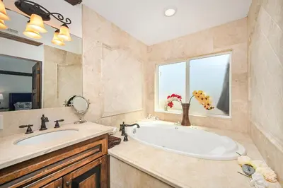 a bathroom with a tub and a sink and a window at 3 Bedroom Luxury Home Steps to Balboa Fun Zone in Newport Beach