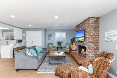 a living room with a couch and a fireplace at 2 Bed 2 Bath Jacuzzi Home with Parking on 51st St in Newport Beach