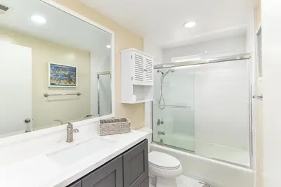 a bathroom with a shower and a sink and a toilet at 2 Bed 2 Bath Jacuzzi Home with Parking on 51st St in Newport Beach