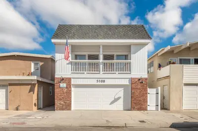 a house with an american flag in front of it at 2 Bed 2 Bath Jacuzzi Home with Parking on 51st St in Newport Beach