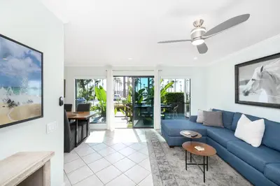 a living room with a blue couch and a table at 5 Bedroom duplex with Patio & Balcony walk to Pier in Newport Beach
