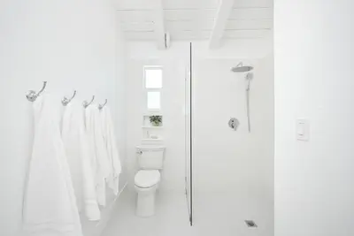 a white bathroom with a toilet and a shower at Great Location near the Balboa Pier and Fun Zone with Air conditioning in Newport Beach