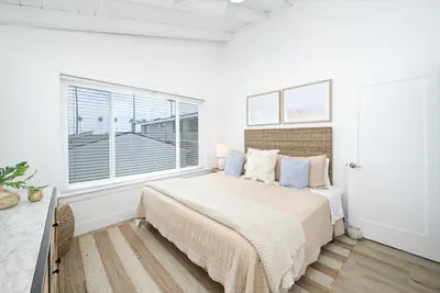 a white bedroom with a bed and a window at Great Location near the Balboa Pier and Fun Zone with Air conditioning in Newport Beach