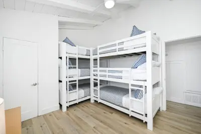 a bedroom with white bunk beds in a room at Great Location near the Balboa Pier and Fun Zone with Air conditioning in Newport Beach