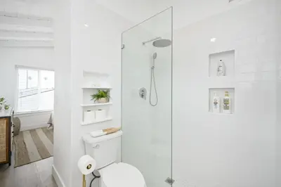 a white bathroom with a shower and a toilet at Great Location near the Balboa Pier and Fun Zone with Air conditioning in Newport Beach