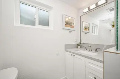 a white bathroom with a sink and a mirror at Remodeled 4 Car with Parking Patio and Firepit in Newport Beach