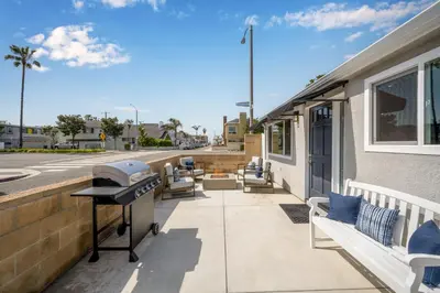a patio with chairs and a grill on a building at Remodeled 4 Car with Parking Patio and Firepit in Newport Beach