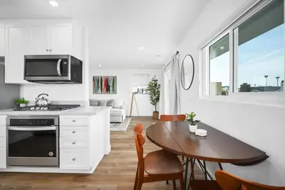 a kitchen and dining room with a table and a stove at Remodeled 4 Car with Parking Patio and Firepit in Newport Beach