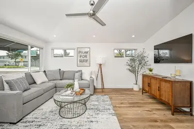 a living room with a couch and a tv at Remodeled Beach Home with 2 Car Parking Patio and Firepit in Newport Beach