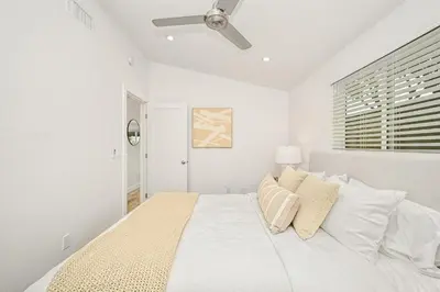 a white bedroom with a large white bed with pillows at Remodeled Beach Home with 2 Car Parking Patio and Firepit in Newport Beach