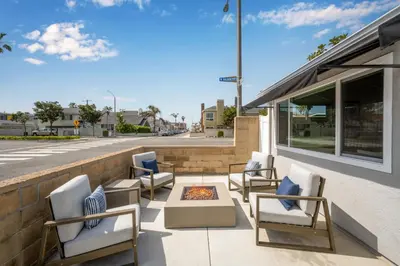 a group of chairs sitting on a patio next to a building at Remodeled Beach Home with 2 Car Parking Patio and Firepit in Newport Beach