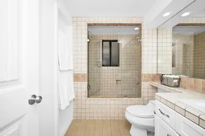a white bathroom with a toilet and a shower at 4 bedroom Home in Quiet Neighborhood near Beach in Newport Beach