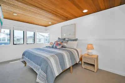 a bedroom with a bed in a room with windows at 4 bedroom Home in Quiet Neighborhood near Beach in Newport Beach
