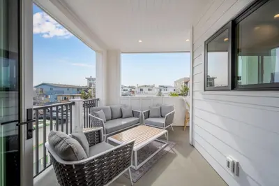 a balcony with chairs and a table on a balcony at 5 Bedroom Luxury Duplex across from the Beach for 11 people in Newport Beach
