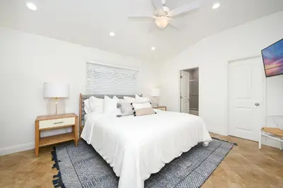 a white bedroom with a bed and a ceiling fan at 3 Bedroom with Park and Beach in your Backyard! in Newport Beach