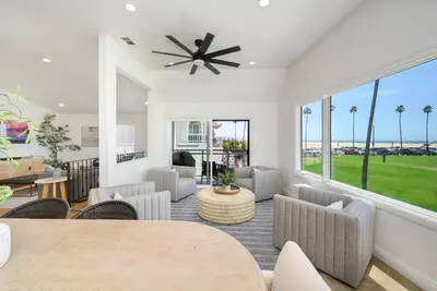 a living room with a table and chairs and a large window at 3 Bedroom with Park and Beach in your Backyard! in Newport Beach