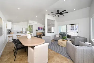 a kitchen and living room with a table and chairs at 3 Bedroom with Park and Beach in your Backyard! in Newport Beach