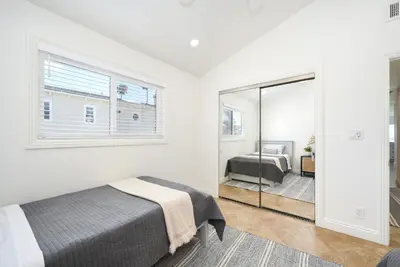 a bedroom with a bed and a mirror at 3 Bedroom with Park and Beach in your Backyard! in Newport Beach