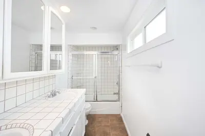 a white bathroom with a tub and a sink at Single Family Home on the Ocean with BEAUTIFUL VIEWS in Newport Beach