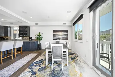 a kitchen and dining room with a table and chairs at Upscale Home with Rooftop Deck, Jacuzzi, & Firepit in Newport Beach