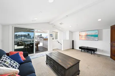 a living room with a couch and a table at Upscale Home with Rooftop Deck, Jacuzzi, & Firepit in Newport Beach