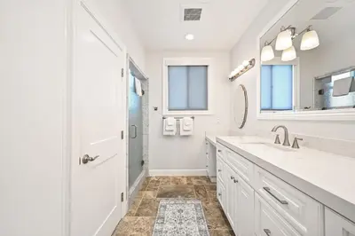 a white bathroom with a sink and a shower at Upscale Home with Rooftop Deck, Jacuzzi, & Firepit in Newport Beach