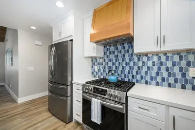 a kitchen with a stove and a refrigerator at Brand New Modern Home by the Beach with Patio & BBQ in Newport Beach