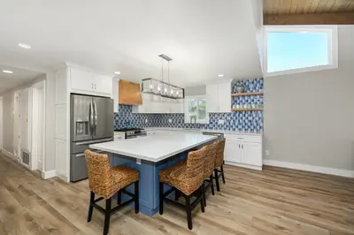 a kitchen with a blue table and chairs at Brand New Modern Home by the Beach with Patio & BBQ in Newport Beach