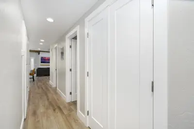 a hallway with white walls and wooden floors at Brand New Modern Home by the Beach with Patio & BBQ in Newport Beach