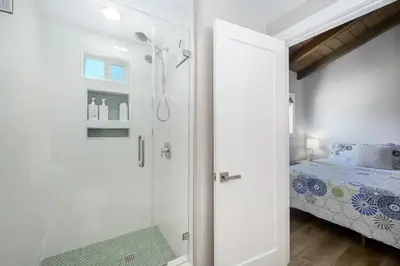 a white bathroom with a shower and a bed at Brand New Modern Home by the Beach with Patio & BBQ in Newport Beach