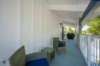 a porch of a house with chairs and a table at Brand New Modern Home by the Beach with Patio & BBQ in Newport Beach